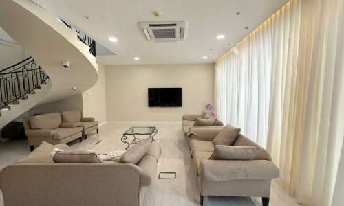 A modern villa in Hamala with a living room featuring couches and a TV.