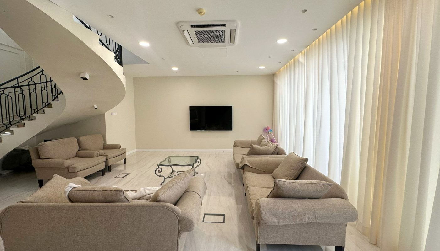 A modern villa in Hamala with a living room featuring couches and a TV.