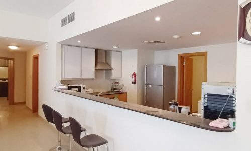 A modern kitchen with a refrigerator and microwave.