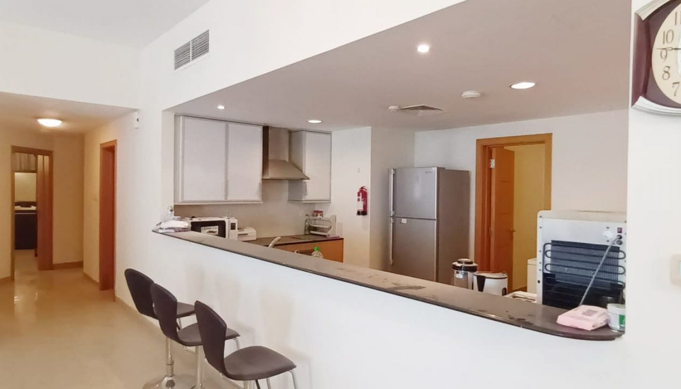 A modern kitchen with a refrigerator and microwave.