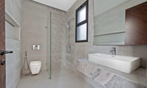 A modern bathroom with a sink and toilet.