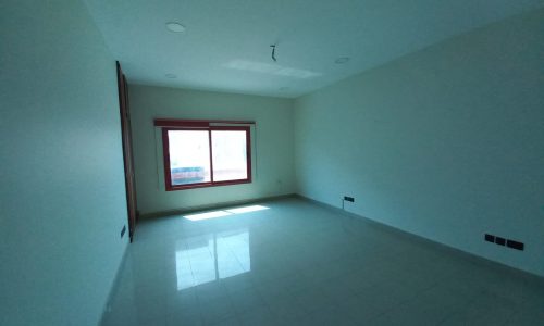 An empty room with white tile floors, a window, available for rent.