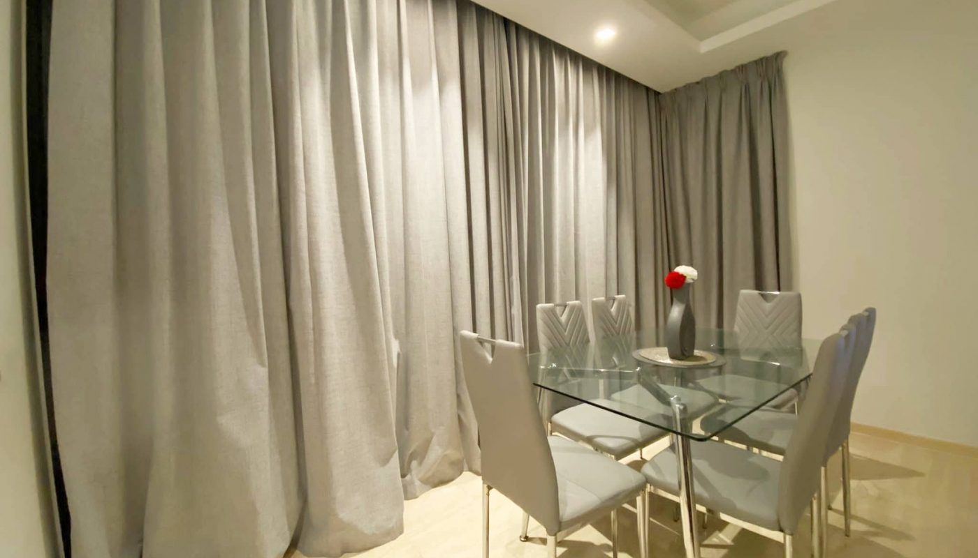 A fully furnished dining room in a rented apartment located in the Dilmunia area, with a glass table and chairs.