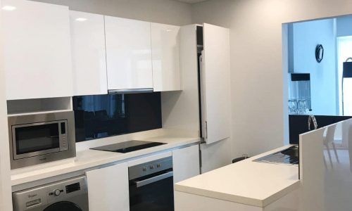 A modern kitchen with a washer and dryer.