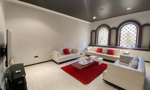 A breathtaking villa for sale in Saar with large windows and a fireplace.