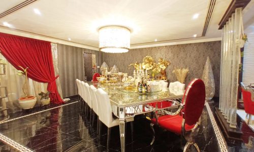 An amazing dining room with red curtains and red chairs.