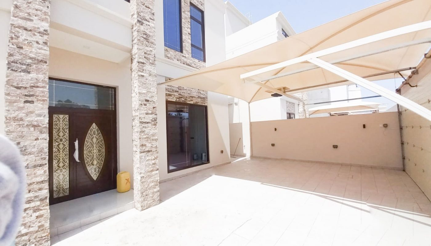 A luxury villa in the middle of a courtyard with an umbrella.