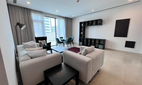 An amazing living room with a couch and TV in an FF 2BR apartment for sale in Amwaj.