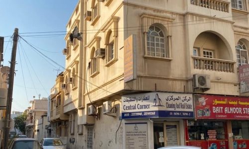 A building in Muharraq with cars parked in front of it for sale.