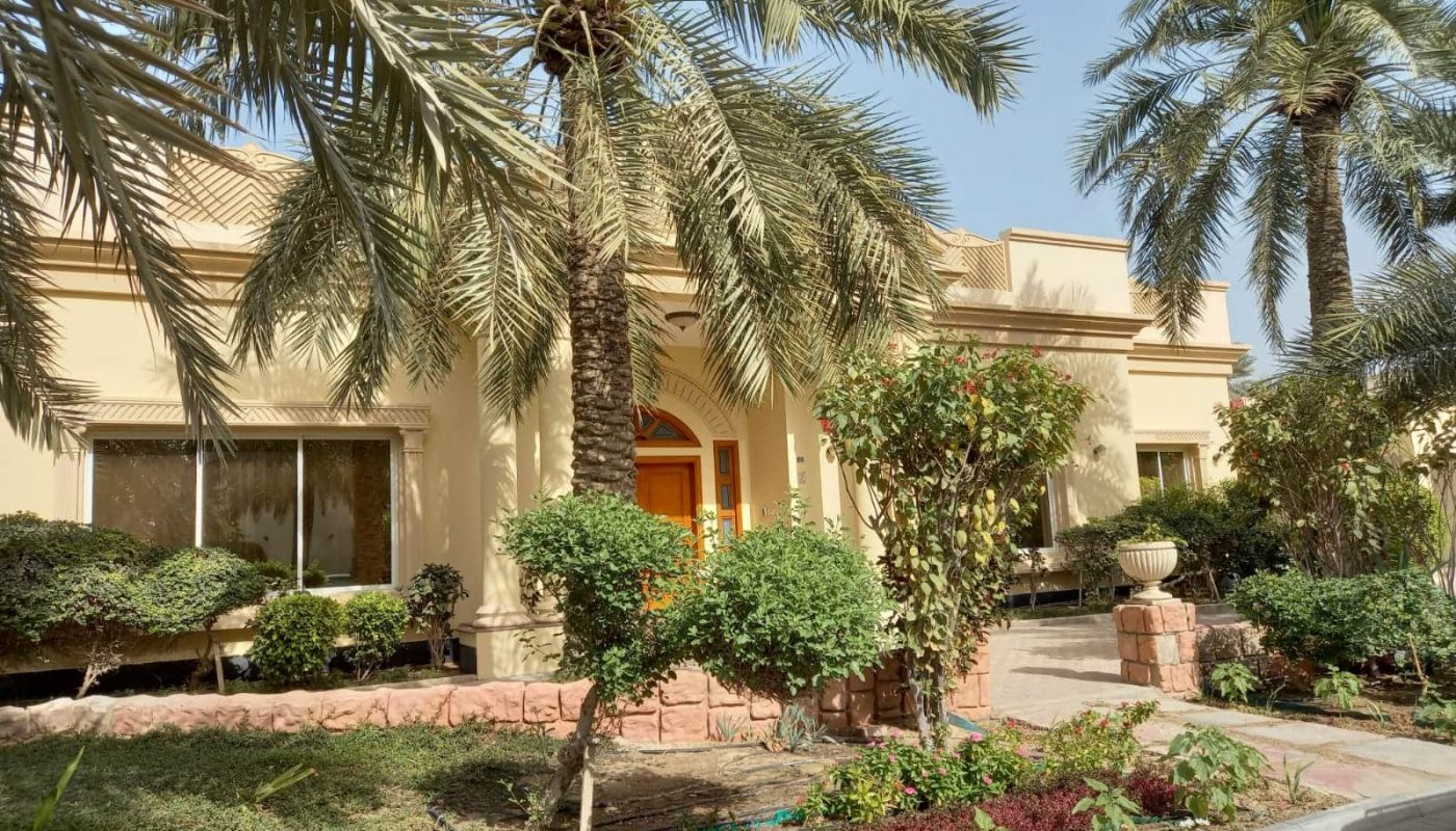 A house with palm trees in front of it.