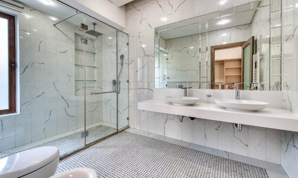 Stunning modern bathroom with marble walls and a glass shower.