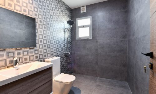 A modern bathroom with luxurious grey tiled walls.