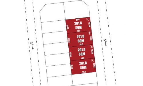 A red and white rectangular sign with numbers and letters, advertising lands for sale in Hamala.