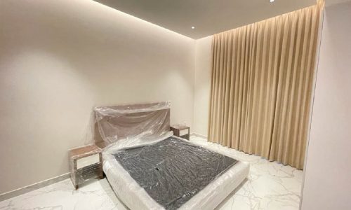 BRAND NEW bedroom with a white bed and marble floor.