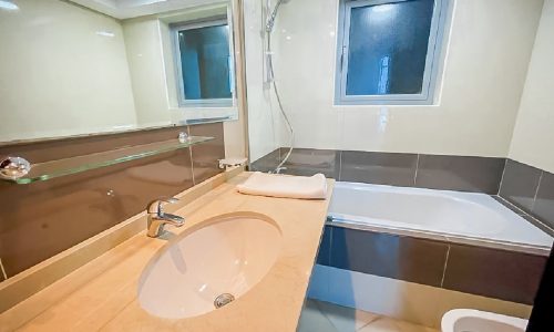 Luxury apartment for rent in Al Mahooz area featuring a bathroom with a sink, toilet, and bathtub.