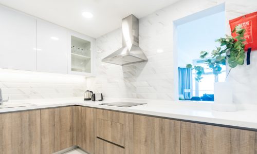 Spacious apartment with white cabinets and wooden counter tops in a new building.