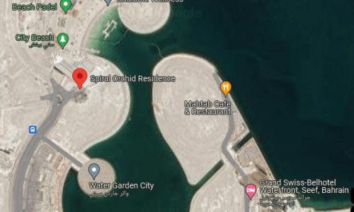 Satellite view of a coastal area in Bahrain Water Bay with circular artificial islands and adjacent roadways.