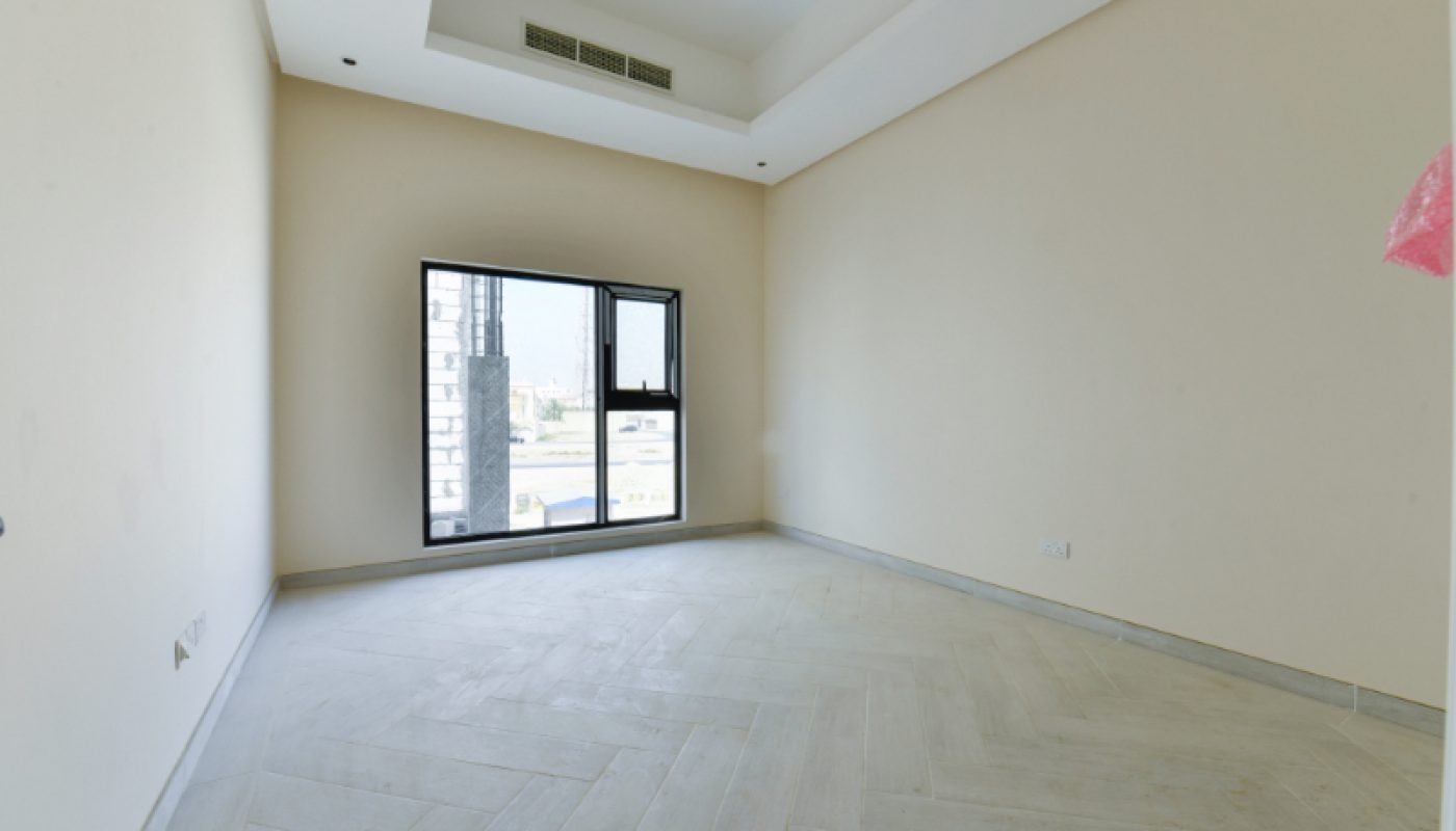 Empty room with cream-colored walls, light tile flooring, a recessed ceiling with vents, and a single window letting in natural light.