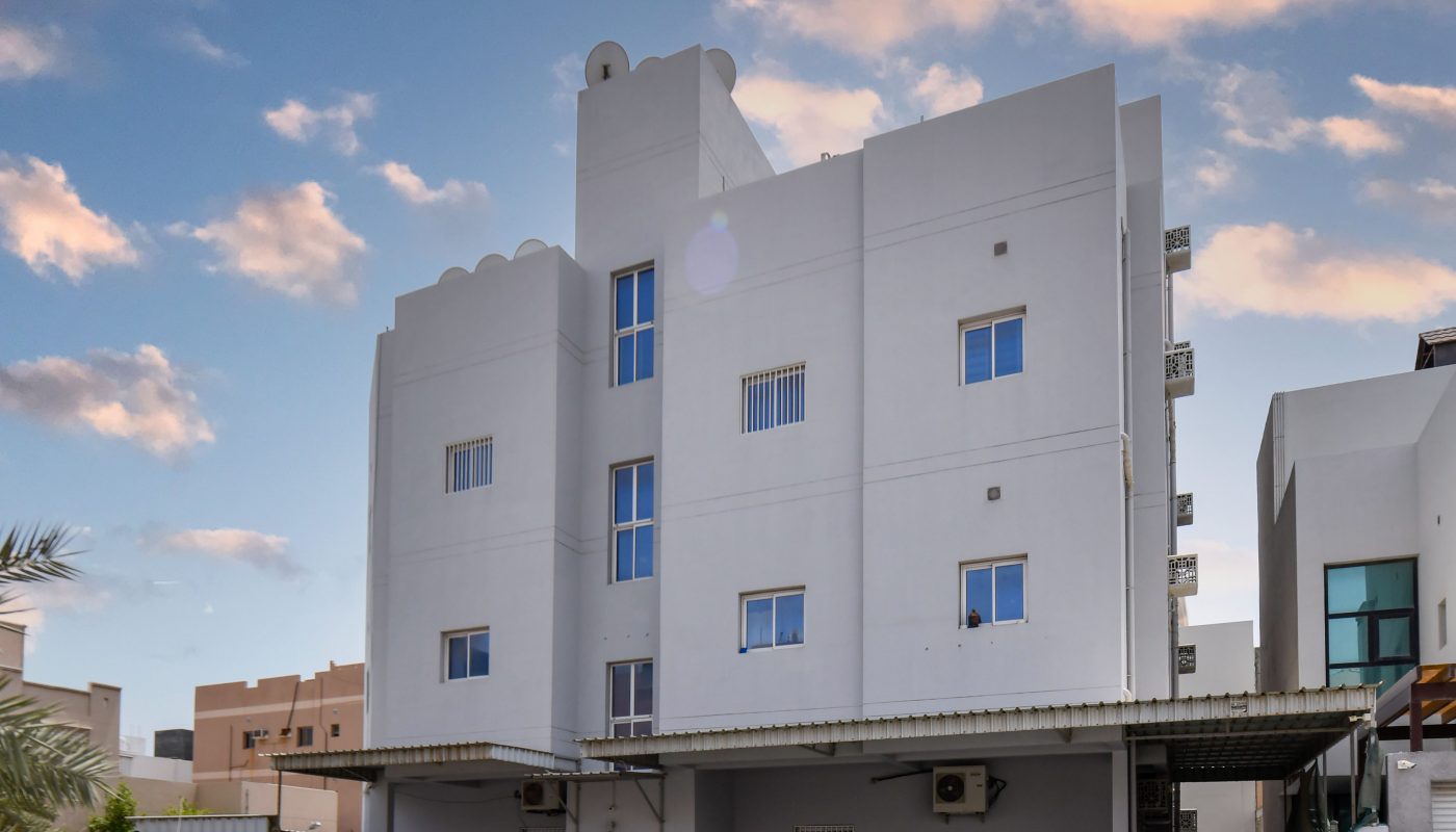 Keywords: White building, cars parked.
