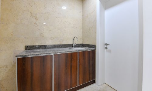 A bright bathroom with a sink and a mirror in offices located in a new building in the heart of Seef.