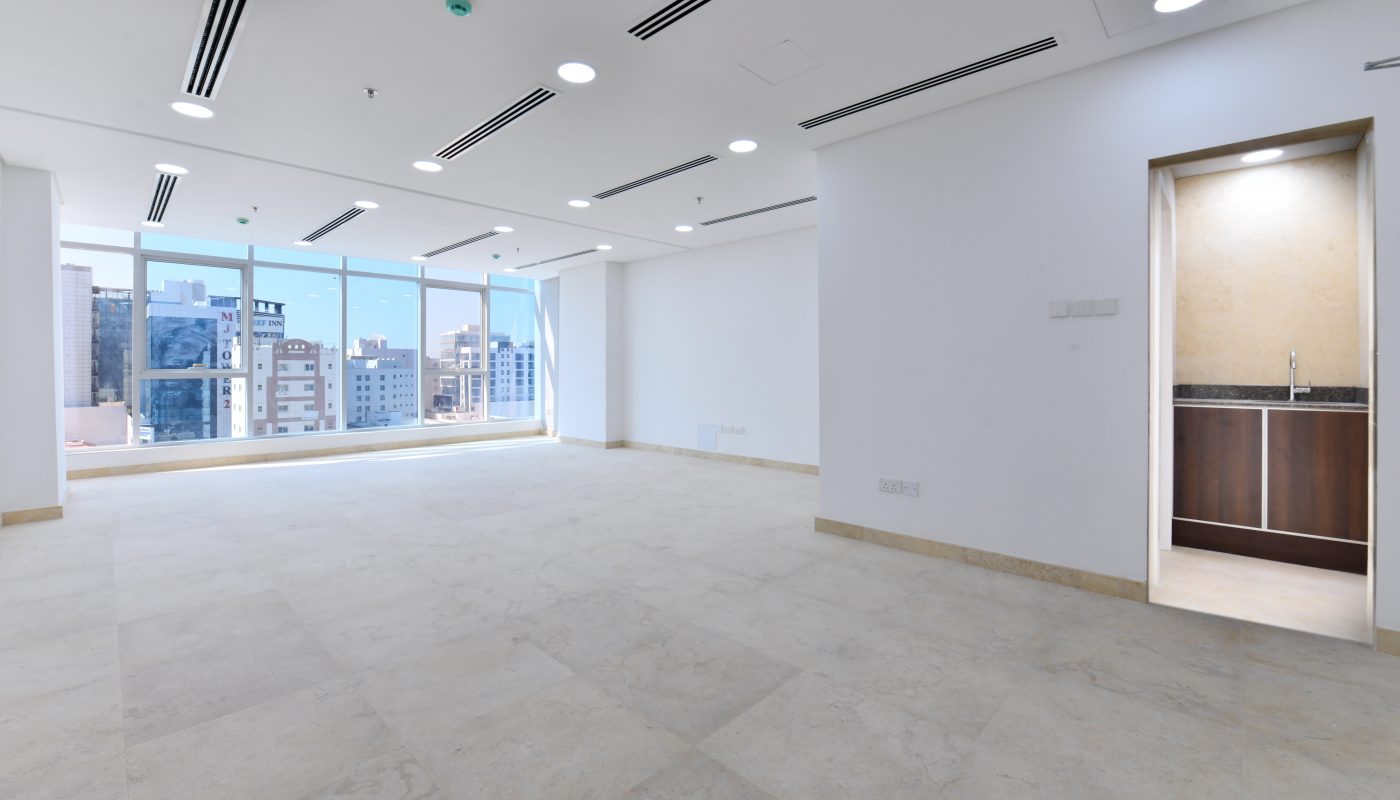 A bright empty room with a view of the city in a new building in the heart of Seef.