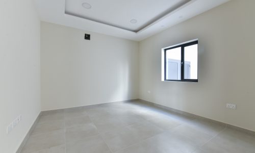 A bright room with tile floors and a window.