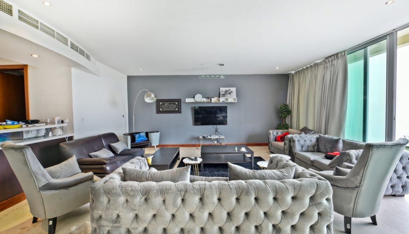 A luxurious living room with large couches and a television.