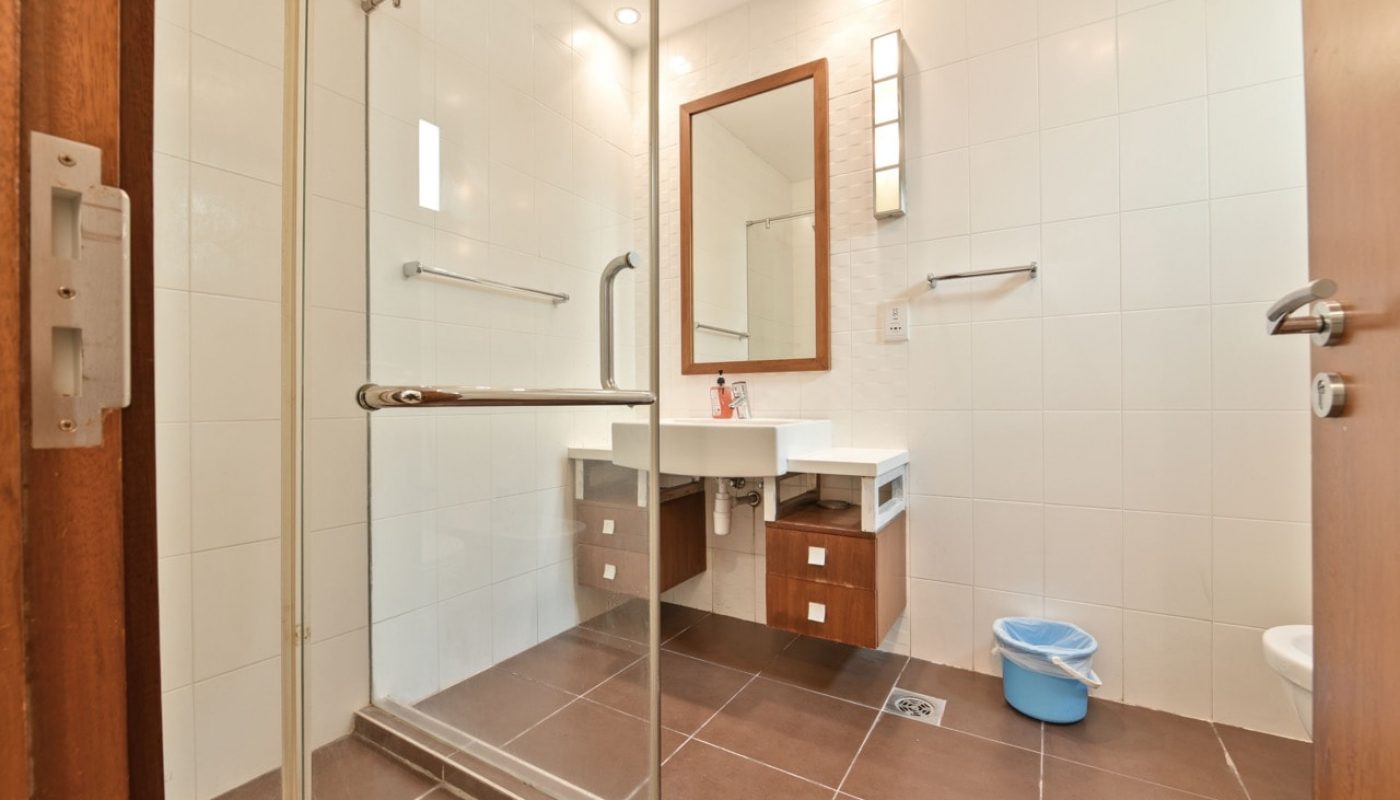 A luxurious bathroom with a glass shower door and toilet.