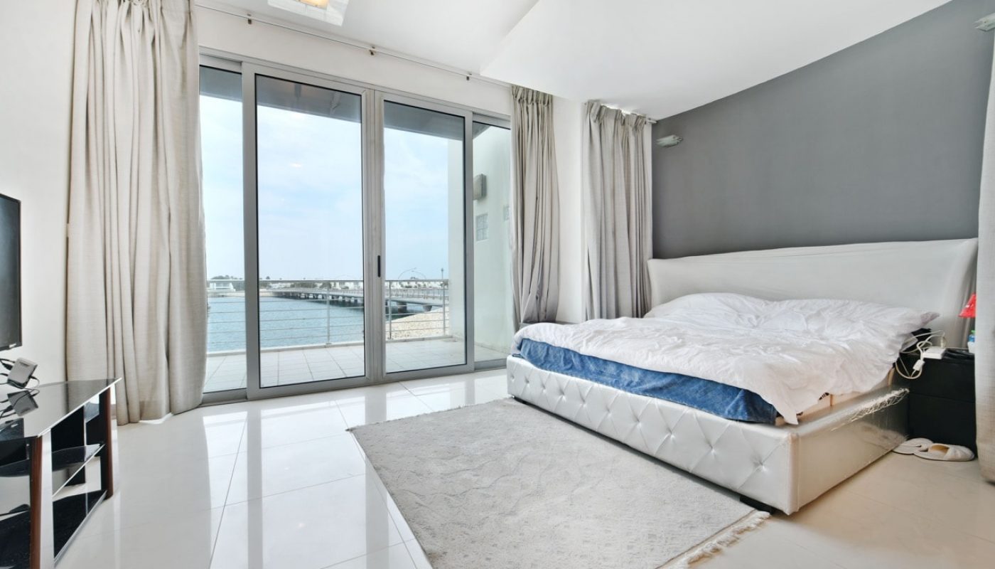 A luxurious bedroom with a bed and a large view of the ocean.