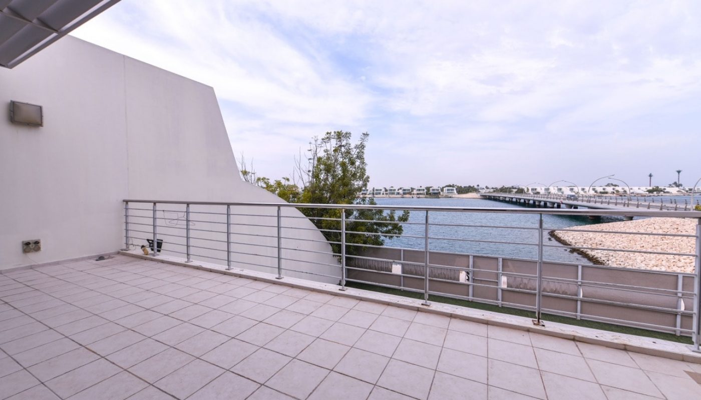 A large balcony overlooking the water with a railing.