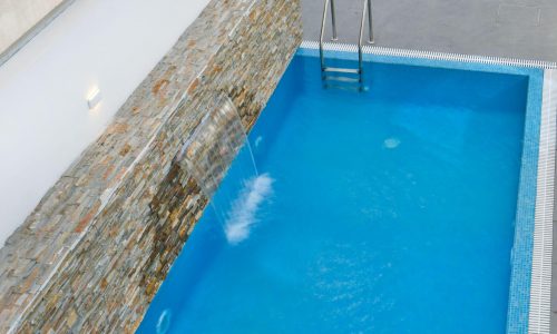 A swimming pool with an auto draft waterfall.