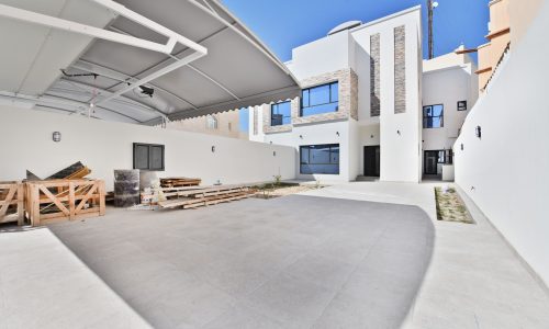 A luxurious villa with a wooden patio and a roof.