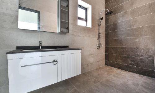 A luxurious villa bathroom with a shower and sink, available for sale in Muqsha.