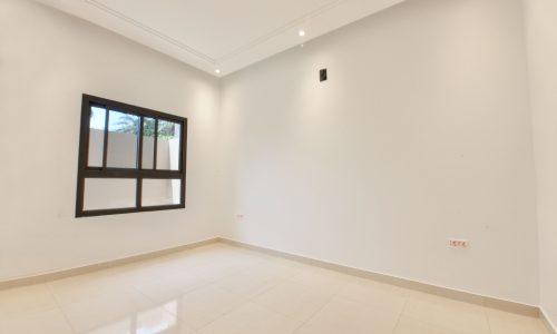 An empty room with white walls and a window is available for sale.