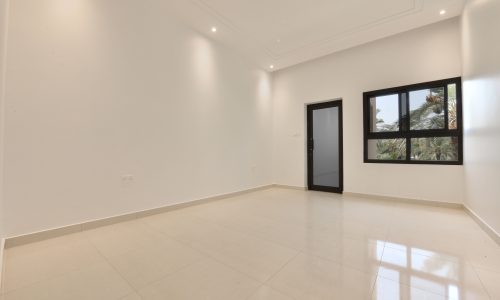 An empty room with white walls and windows for sale.