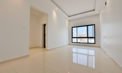 An empty room with white walls and tile floors awaits in the villa.