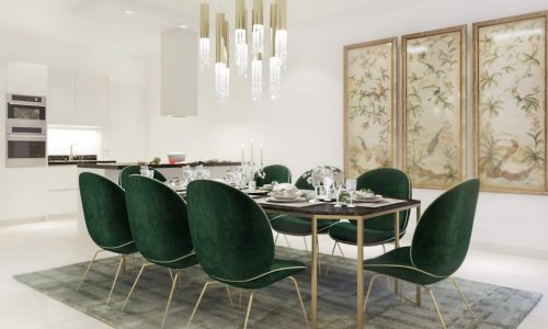 A luxurious dining room in a 4BR villa featuring green velvet chairs.