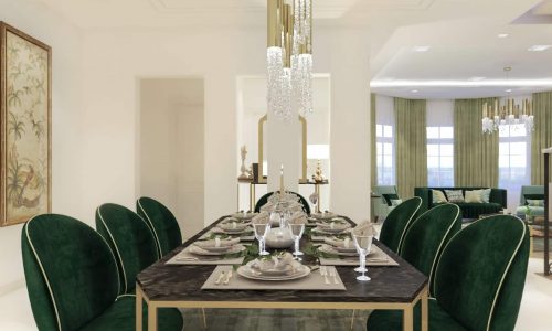 Luxury dining room with green chairs and a gold chandelier in a 4BR villa for sale in Durrat Al Muharraq with garden.