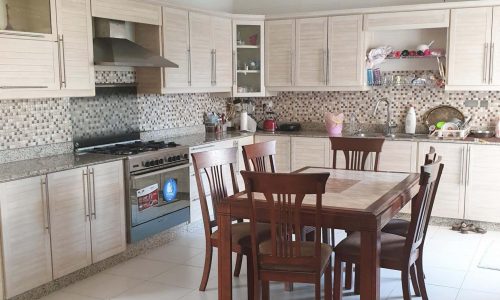 Luxury kitchen with table and chairs in a 6BR Villa for Sale in Amwaj Area.