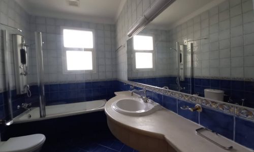 A luxurious 4BR villa, located in the Green Lash Compound, featuring a blue tiled bathroom with a sink and toilet.