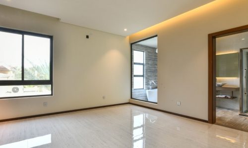 A modern empty room with a large window and a sliding door.