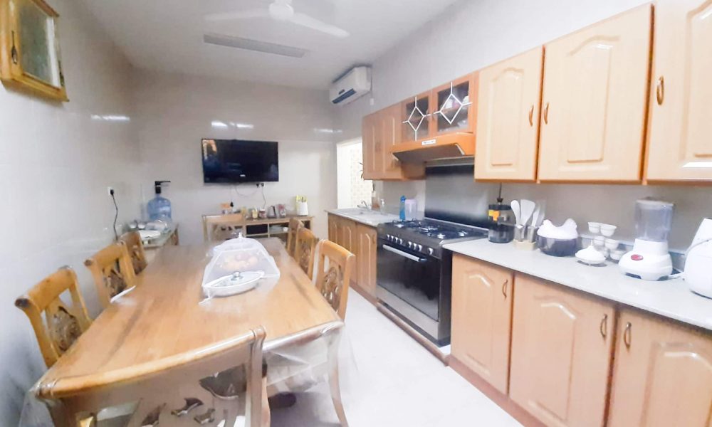 A luxurious kitchen featuring a table, chairs, and a refrigerator is part of an 8BR Villa for Sale in Samaheej.