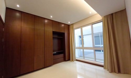 A luxurious room with wooden cabinets and a large window in a private villa.