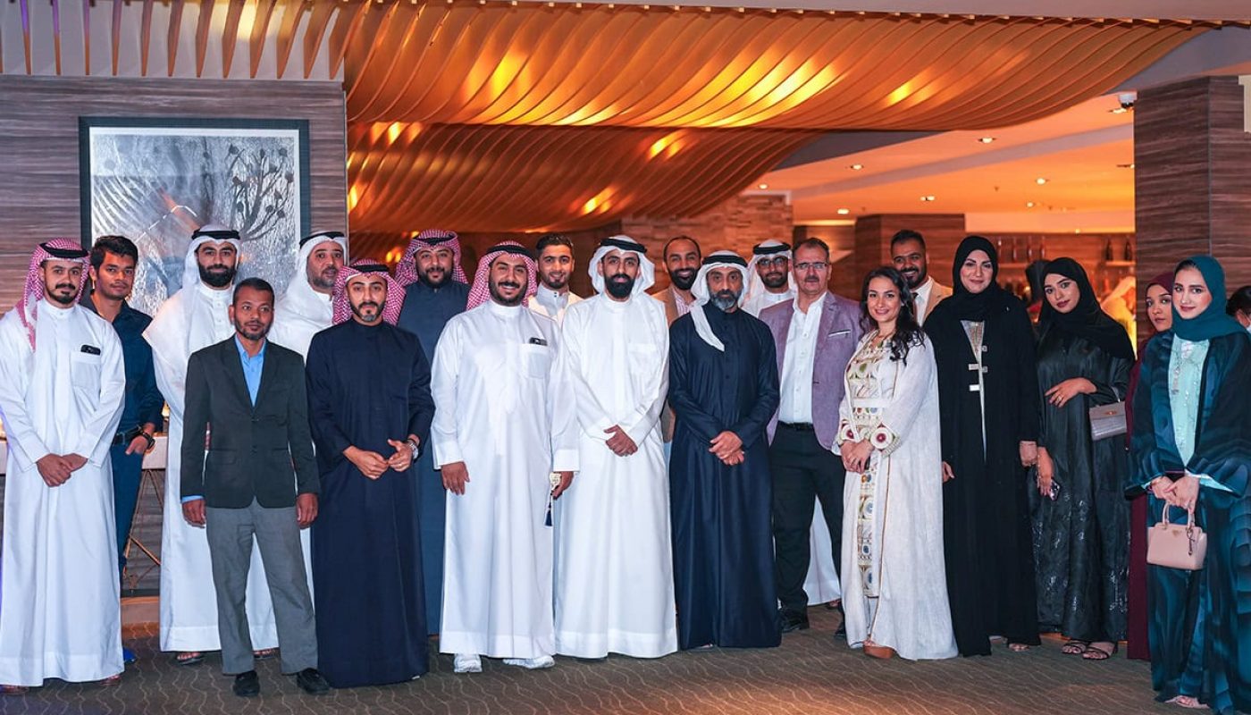 Employees from House Me gather for a Ramadan Ghabga, dressed in formal and traditional attire, posing together indoors in a well-lit, modern setting.
