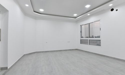 An empty room with white walls and a door in a brand new luxury 3BR flat for sale in Saar.