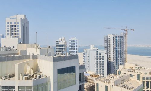 An amazing 1 bedroom flat for rent in Juffair with a view of tall buildings and a beach.