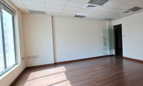 An empty Seef office with wooden floors and windows.