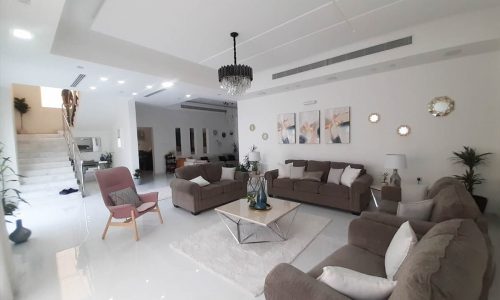 A luxurious living room with couches and a coffee table in a quiet area of Saar, Bahrain.