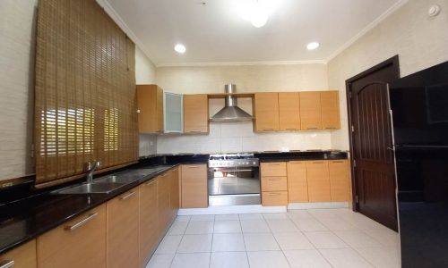 A stunning kitchen with stainless steel appliances and wooden cabinets in a bright 4 bedrooms villa near Saar Mall.