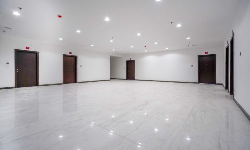 A spacious room with white walls and doors available for rent in Budaiya.